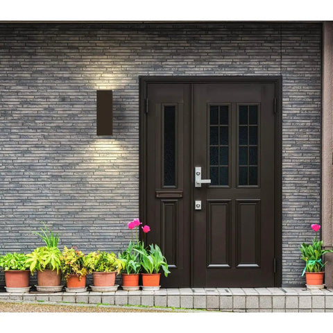 Aluminum Outdoor Up And Down Wall Lantern Light in Antique Bronze by door, 6 inch square sconce illuminating entrance.