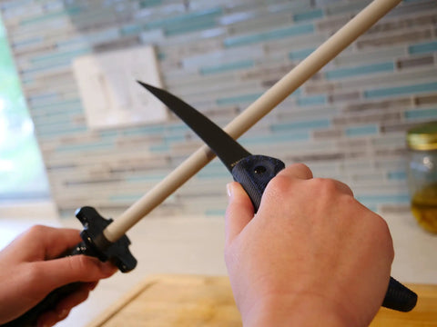 Using CS2 Ceramic Knife Sharpener and Honing Rod 12 Inch for kitchen knife sharpening against polished ceramic surface