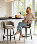 Woman sitting on Set of 6 30 Inch Swivel Bar Stools With Curved Back Mid Century Modern Faux Leather Upholstery in Matte Gray