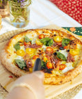 Heavy Duty 14 Inch Bamboo Pizza Peel And Wooden Spatula Paddle For Backyard Cookouts with pizza on a rustic serving board.