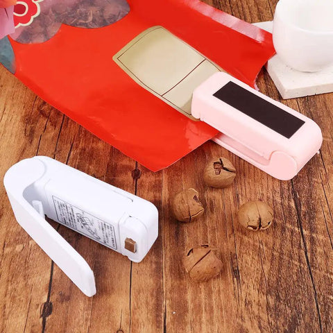 Slick Mini Portable Handheld Bag Sealer For Fresh Snack Storage And Grocery Plastic Packaging Clamps Hassle Free Heat Seal Tool Compact Kitchen Gadget White beside open snack bag.