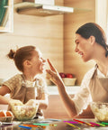 Mother and daughter joyfully baking in a kitchen, using the Top Shelf 14 Piece Fondant Cake Decorating Kit for fun pastry moments.