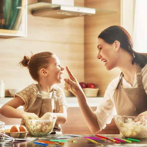 Mother and daughter joyfully baking in a kitchen, using the Top Shelf 14 Piece Fondant Cake Decorating Kit for fun pastry moments.