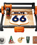 ACMER S2 12W laser engraver in orange/black frame with 300x300mm bed, engraving a Route 66 wooden sign.