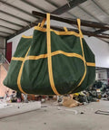 Rock Solid Heavy Duty Crane Lifting Bag Anti Tear Reusable Cargo Net hanging in a warehouse, showing thick nylon material and straps.
