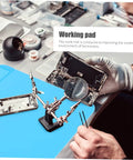 Heavy Duty Silicone Soldering Mat Heat Resistant Workbench Repair Pad For Phones Tablets PC And Watches, blue work surface with magnifying tool.