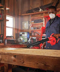 Person using V20 Cordless Leaf Blower Bare Tool, 125 MPH Max Air, 3 Speed Selector in a workshop for quick debris clearing