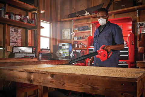Person using V20 Cordless Leaf Blower Bare Tool, 125 MPH Max Air, 3 Speed Selector in a workshop for quick debris clearing