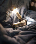 Lighthouse Micro Flash Lantern USB Rechargeable Handheld Light for Emergency Outdoor Use shining on a sleeping bag
