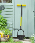 Heavy Duty Steel Workhorse Half Moon Edge Tool With Saw Tooth Blade resting against garden shed