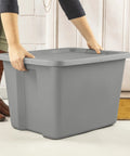 Person lifting a Built Tough Eighteen Gallon Storage Bin With Secure Snap Lid Heavy Duty Stackable Tote For Clutter Control Hella Roomy Gray Plastic Organizer Zero Fuss.