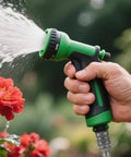 Hand watering flowers with a green hose nozzle attached using Heavy Duty Stainless Steel Garden Hose Quick Connect Fittings Three Quarter Inch GHT 2 Pack No Tools Required Leak Free Quick Connectors For Hoses And Sprayers With One Hand Operation.