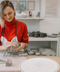 Heavy Duty Pottery Circle Divider Lays Dead Center For Precision Clay Slab Layout And Ceramic Wheel Projects illustrating usage by an artist.
