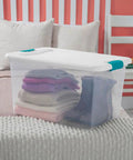 Super Tight Fit 64 Quart Clear Plastic Storage Bins 72 Pack With Snappy Hinged Lids, holding folded blankets on a bed.