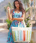 Model with Waterproof Beach Tote for Women with large capacity, foldable rainbow stripe design at a sunny location
