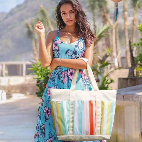 Model with Waterproof Beach Tote for Women with large capacity, foldable rainbow stripe design at a sunny location