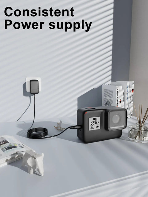 AC DC Wall Charger For Elliptical Machine Power Supply Cable connected to a camera on a desk with books and decor