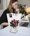 Clear Plastic Flower Packaging Bags With Handle For Bouquets on office desk next to woman using laptop, featuring red flowers inside.