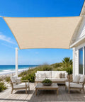 Beige 5 By 8 Foot Sun Shade Sail With Straight Edge For Patio And Pergola Outdoor UV Protected HDPE Shade Fabric Rectangle Awning Cloth With Corner D Rings Customizable Size installed over outdoor seating area by beach.
