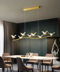 Badass Brass Bird Pendant Light Slick Modern Ceiling Fixture With Ultra Smooth Lighting And Zero Glare For Restaurants Bedrooms Offices And Hotel Hallways Game Changing Room Decor above dining table with eight birds.