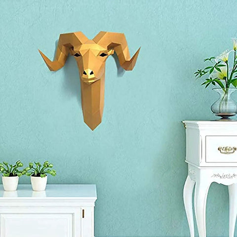 Gold geometric ram head wall decor on light blue wall with potted plants and white furniture.