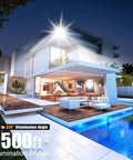 Modern house illuminated by Led Outdoor Flood Light 150W 13500Lm with 330 Degree Coverage, highlighting exterior and pool at night.