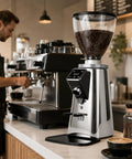 Commercial Coffee Grinder With 64mm Flat Burrs 750g Bean Hopper Timed Single Double Dose Digital Display next to espresso machine.