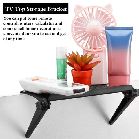 Kick Off Your Desk Upgrade With This Super Solid Black Tv Top Shelf Bracket 2 Pack Monitor Riser Stand For Gaming Setups Gonna Look Dead Legit Today, featuring a compact shelf with remote and decorative plants.