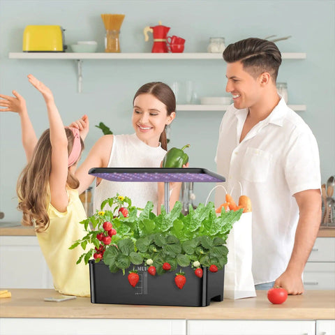 Family using 12 Pod Hydroponics Growing System With LED Grow Light For Indoor Garden on kitchen counter; plants growing inside.