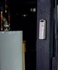 Wireless Indoor Outdoor Temperature And Humidity Sensor With A B C Switch installed on black wall in utility room