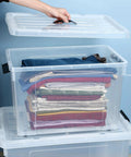 Person placing lid on Clear Stackable Plastic Containers for Garage Setup, Two Pack 40 Gallon Heavy Duty Storage Bins With Smooth Rolling Wheels And Clinch Tight Lids.