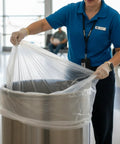 Heavy Duty 40 45 Gallon Trash Bags With Clear Scent Free Build Featuring No Nonsense Tear Resistant Polyethylene And Star Seal Bottom For Straight Up Leak Proof Cleanup In Every Standard Waste Bin being placed in a stainless steel waste bin.