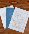 Color Carbon Transfer Paper Set With 50 Sheets In Red Yellow Blue Green White 9x11 Inch Graphite Paper And 5 Stylus Tools displayed on wooden surface with outlined flower design.