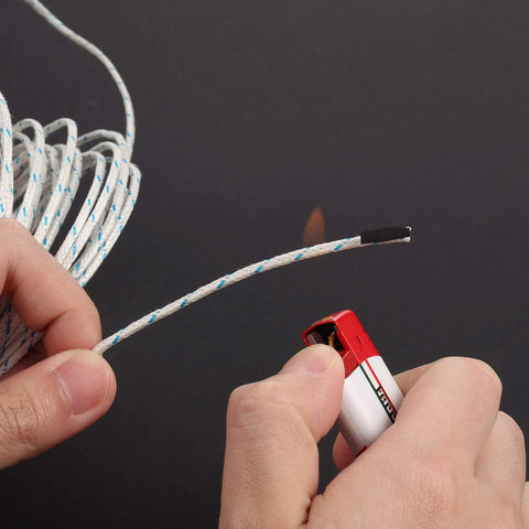 Close-up view of white braided K-type thermocouple wire with blue tracers, 3 m length, being cut on a dark surface