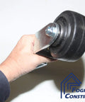 Person holding rugged heavy duty gate and door caster with spring loaded suspension, 4 inch fixed wheel, square shaft.