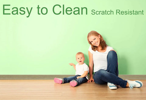 Woman and child sitting on floor with Moisture Resistant Vinyl Baseboard Molding With Wood Grain Finish Quarter Inch Thick Four Inch Tall Rubber Wall Base Trim Waterproof Base Molding For Bathrooms Basements Garages Sixteen Foot Length Easy Install against a green wall. Text reads 'Easy to Clean Scratch Resistant.'