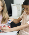 Slice mini box cutter, blue plastic handle, retractable blade used by a child to open packaging.