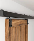 Five-Foot Box Rail Sliding Barn Door Hardware Kit With Wall Mount Track for interior openings, black powder coated, installed on a wood door.