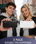 Two young adults holding a black and white Slim Two Pack Portable Charger And 10000 Mah Power Bank For Travel, ready to charge gadgets.