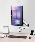 Desk Clearing Wall Mount Monitor Arm With Butter Smooth Mechanical Spring Adjustment Fits 12 To 27 Inch Screens mounted beside desk.