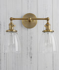 Double Sconce Wall Light Set Vintage Industrial Antique Vibe With Two Oval Cone Clear Glass Shades mounted on white wall