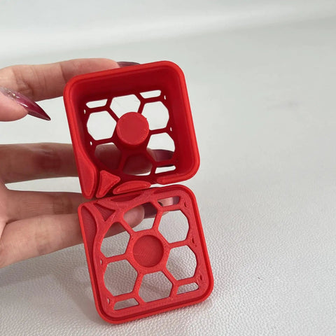 Label Dispenser Storage Box For Desk And Home Office, Space Saving Organizer Tray For Labels, Stickers, And Supplies, Lightweight, Durable, And Tidy Desktop Organizer For Efficient Desk Storage. Red plastic honeycomb label dispenser box shown open in hand