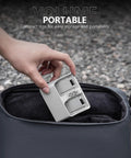 Hand placing Two Way Charging Hub For DJI Neo Drone Batteries into a bag, showcasing portability and dual charging slots.