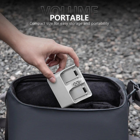 Hand placing Two Way Charging Hub For DJI Neo Drone Batteries into a bag, showcasing portability and dual charging slots.