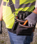 Person wearing Cut Resistant Work Gloves With Nitrile Coated Grip, HPPE Fabric, XL Size, holding a tool pouch