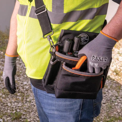 Person wearing Cut Resistant Work Gloves With Nitrile Coated Grip, HPPE Fabric, XL Size, holding a tool pouch