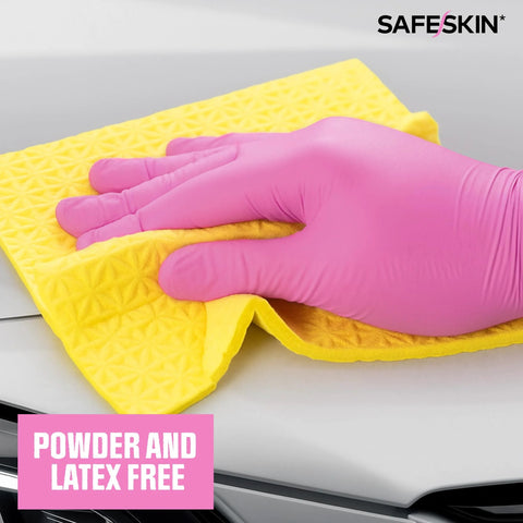 Close-up of magenta nitrile disposable glove wiping a car hood with a yellow microfiber cloth; SafeSkin logo visible