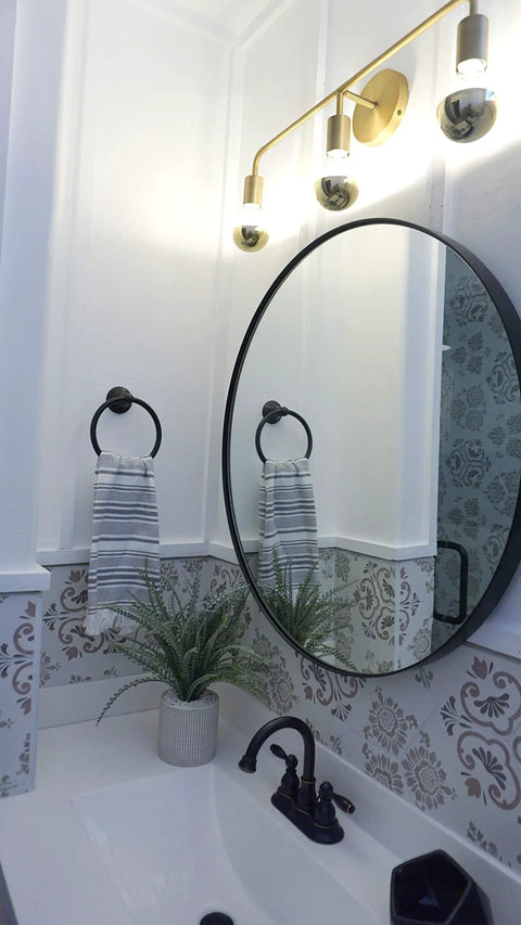 Brass Three Light Vanity Wall Fixture For A Modern Farmhouse Bathroom Vibe, 24 Inch Wide with exposed bulbs over oval mirror