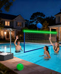 Pool Volleyball Net Set With LED Lights And Solar Panel For Lit Nights By The Pool Adjustable 15 To 32Foot Length Inground Pools Outdoor Backyard Water Volleyball Game Toy For Parties, installed next to a pool at night with glowing LED lights.