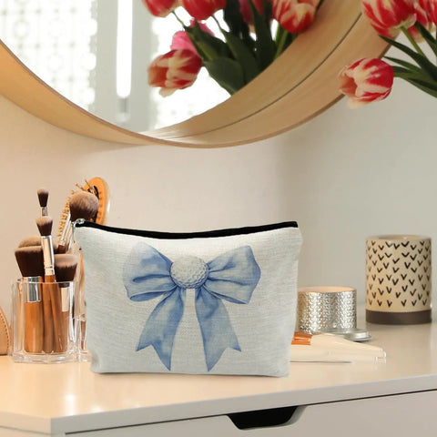 Golf Themed Makeup Bag For Women, blue golf ball bows cosmetic pouch on a vanity table with brushes, 10x7.5 inch.